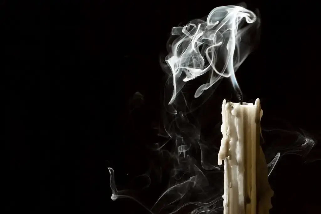 Photo of a candle being blown out.