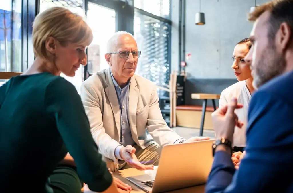 Photo of an older person mentoring people
