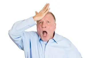 Photo of an older man slapping his forhead.