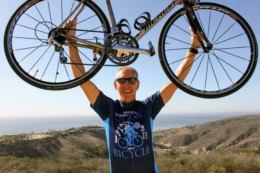 Photo of Glenn Frommer holding his bike. Image courtesy of Ride For PKD.