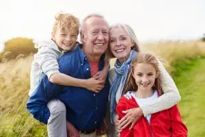 Photo of grandparents with their grandchildren outdoors.