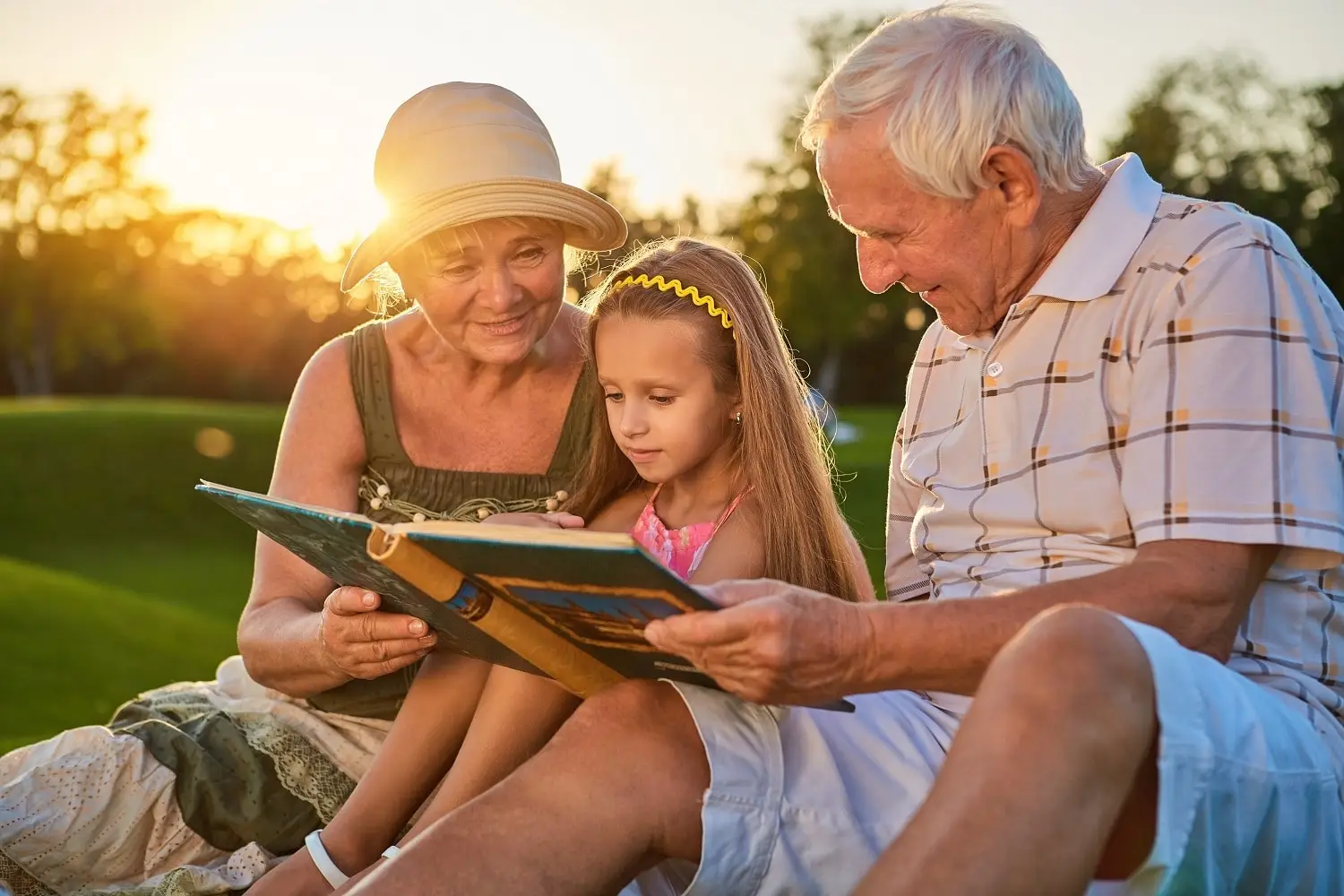 Photo of grandparents reviewing a photo album with a child.
