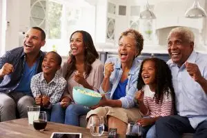 Photo of multi-generational family enjoying television.