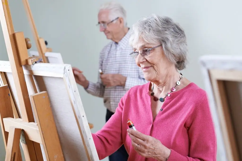 Photo of an older couple creating paintings.