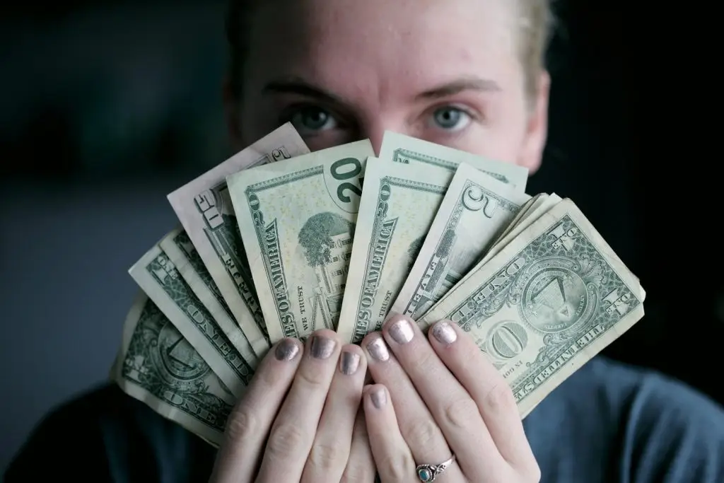 Photo of someone holding paper money taken by Sharon McCutcheon at Unsplash.