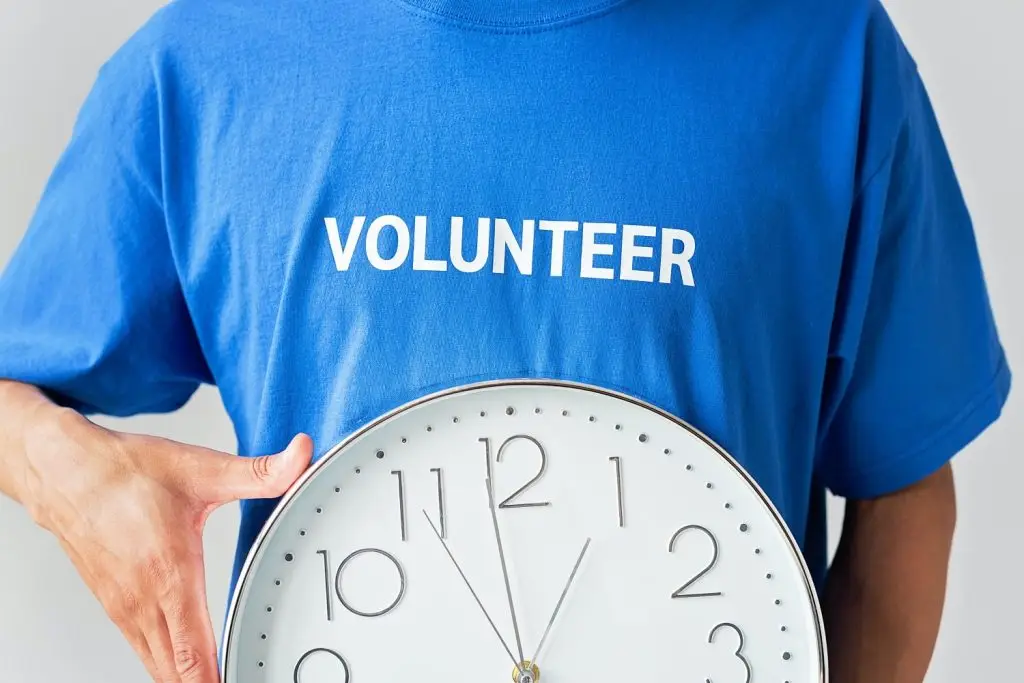Photo of a volunteer holding a clock taken by Mikhail Nilov at Pexels