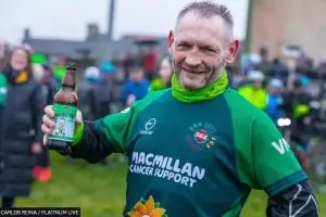Gary McKee celebrates after completing 365 marathons in 2022. Photo by Carlos Reina at Platinum Live and published by the BBC.