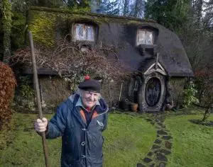 Photo of Stuart Grant in front of his Hobbit house. Photo appeared at SWNS.