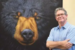 Photo of David Berge with one of his paintings.