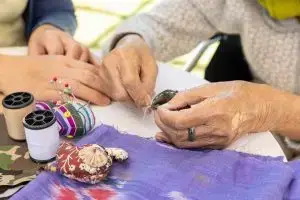 Photo of daughter helping elderly mother with crafts.