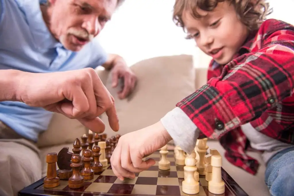 Photo of older man and younger boy playing chess.