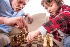 Photo of older man and younger boy playing chess.