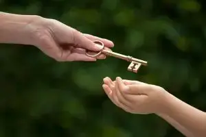 Photo of an adult handing over a key to a child