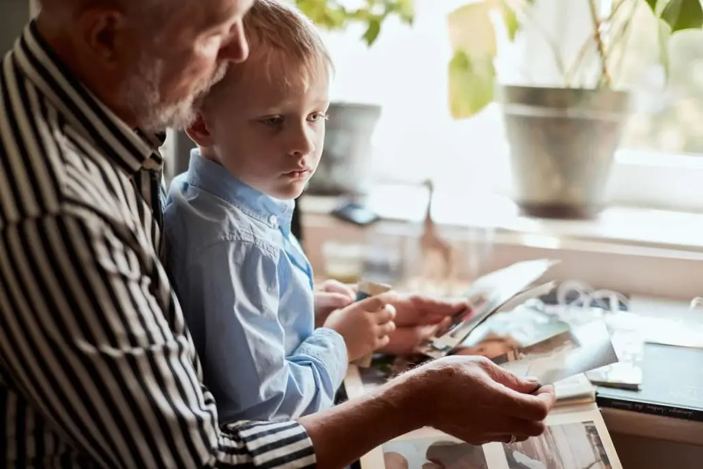 Photo of a grandfather and grandson looking at old pictures.