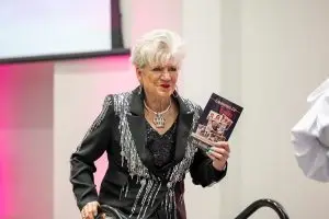 Photo of Jill Rumbley Beam with her book, "Growing Up Rumbley."